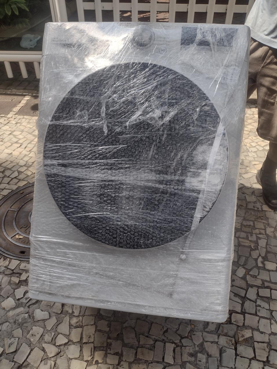 Máquina de lavar embalada com plástico bolha e stretch pela equipe Dos Santos Transportes